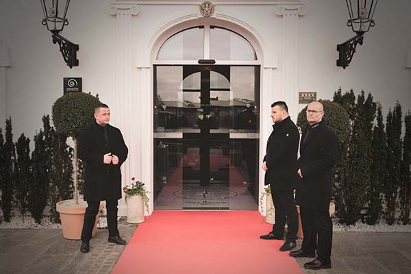 Patronus Mitarbeiter stehen auf einem Roten Teppich vor dem Eingang eines Hotels